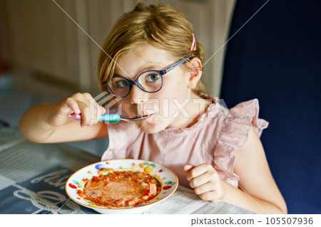 Little preschool girl eating from spoon vegetable potato soup. Healthy food for children. Happy kid at home or nursery. Little preschool girl eating from spoon vegetable potato soup. Healthy food for children. Happy kid at home or nursery. 105507936