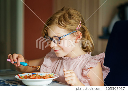 Little preschool girl eating from spoon vegetable potato soup. Healthy food for children. Happy kid at home or nursery. Little preschool girl eating from spoon vegetable potato soup. Healthy food for children. Happy kid at home or nursery. 105507937