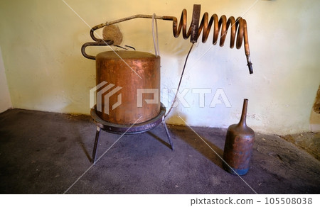Distillation of lavender essential oil and hydrolate. Copper alembic for the flowering field. In dark rooms. little light 105508038