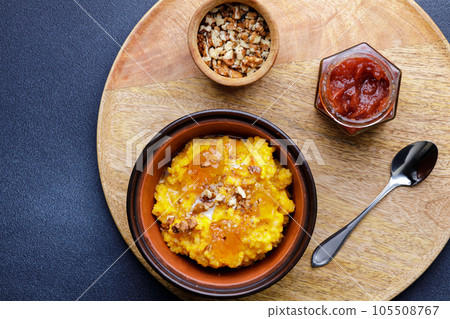 Sweet pumpkin porridge in clay bowl with jam and nuts 105508767