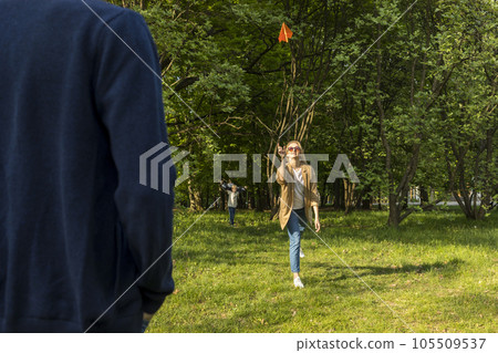 Real Family Have Fun, Playing Game In Meadow, Happy Smiling Boy Run on Background. Summer Time. Parents Day, Family Leisure Time. Emotional Connection, Love And Care. Horizontal Plane. 105509537