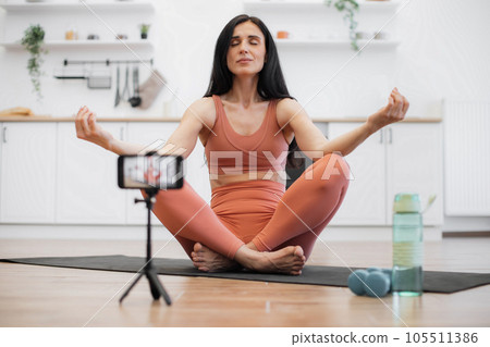 Blogger using tripod with smartphone for recording video 105511386