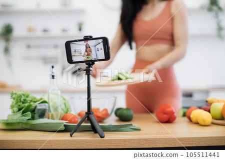 Smartphone capturing salad cooking process by lady at home 105511441