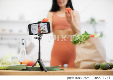 Female vlogger shooting video about foods via smartphone 105511741