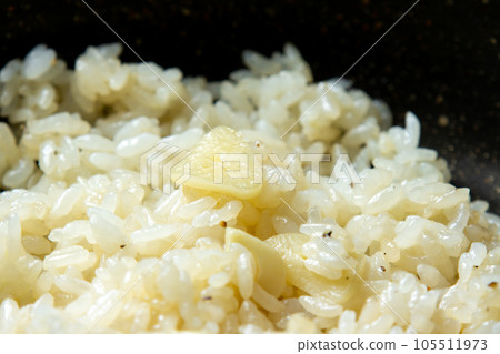 A close-up of a cooking scene where garlic rice is made in a frying pan. A close-up of a cooking scene where garlic rice is made in a frying pan. 105511973