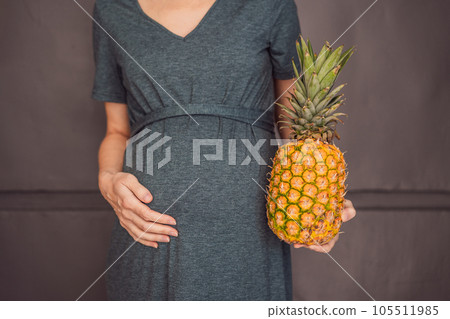 A pregnant woman's belly, beautifully showcasing the size of her baby, likened to a pineapple. Explore the potential benefits and harms of pineapple during pregnancy and childbirth 105511985
