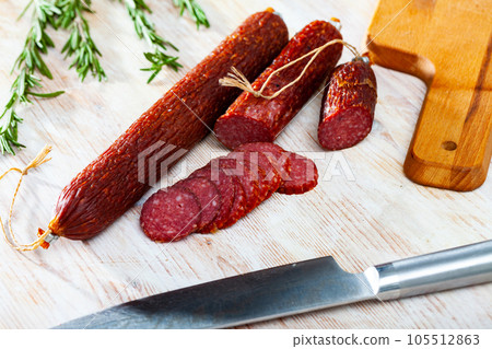 Fresh smoked russian sausage cut in slices on wooden surface 105512863