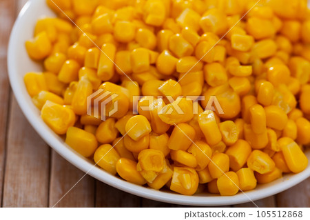 Grains boiled corn on plate on wooden table. Vegetarian ingredient Grains boiled corn on plate on wooden table. Vegetarian ingredient 105512868