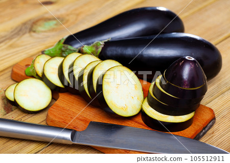 Sliced aubergine on wooden table 105512911