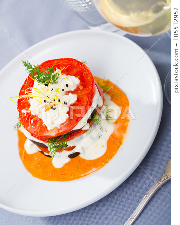 Dish of tasty eggplants with tomatoes on spicy sauce at white plate Dish of tasty eggplants with tomatoes on spicy sauce at white plate 105512952