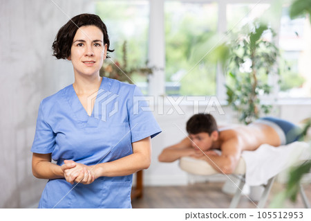 Portrait of friendly female masseur with an inviting visit to spa salon Portrait of friendly female masseur with an inviting visit to spa salon 105512953