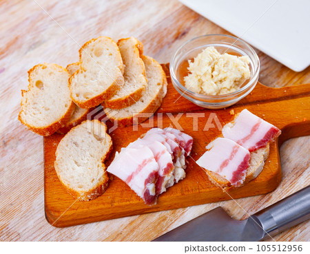 Snack for vodka, homemade salo with bread and horseradish on rustic board Snack for vodka, homemade salo with bread and horseradish on rustic board 105512956