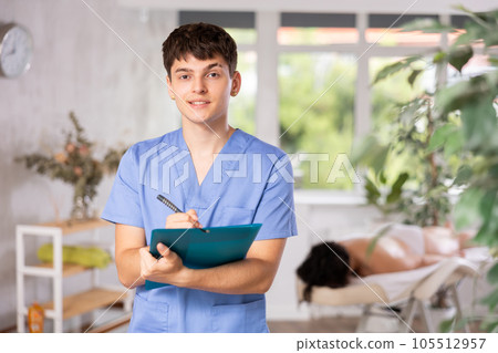 Male masseur with document holder in spa salon Male masseur with document holder in spa salon 105512957