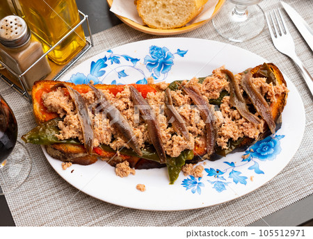 Toasted bread with chopped tuna, anchovies and baked bell pepper Toasted bread with chopped tuna, anchovies and baked bell pepper 105512971