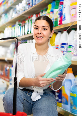 Young woman looking to buy laundry detergent in supermarket 105513235