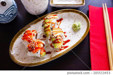 Uramaki sushi rolls with avocado, salmon and unagi sauce Uramaki sushi rolls with avocado, salmon and unagi sauce 105513453