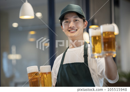 Image of a young man holding a beer mug restaurant hall staff 105515948