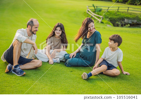 A loving family enjoying a leisurely walk in the park - a radiant pregnant woman after 40, embraced by her husband, and accompanied by their adult teenage children, savoring precious moments together 105516041
