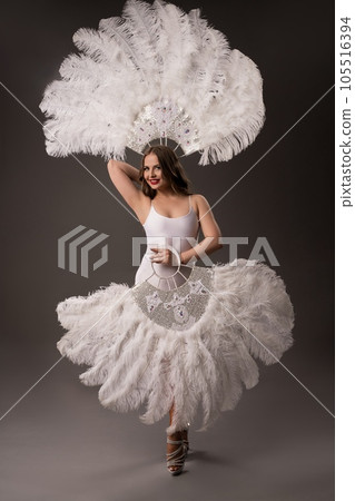 Smiling dancer in white bodysuit with feathers fans 105516394