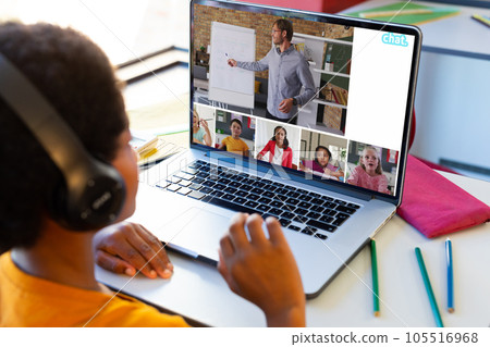 Biracial boy having a video conference with caucasian male teacher and diverse students on laptop 105516968