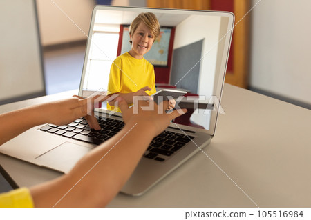 Caucasian boy having laptop video call with happy caucasian boy using tablet Caucasian boy having laptop video call with happy caucasian boy using tablet 105516984