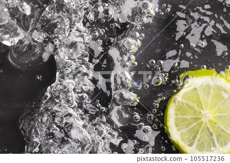 Close up of lime slice in water with copy space on black background Close up of lime slice in water with copy space on black background 105517236