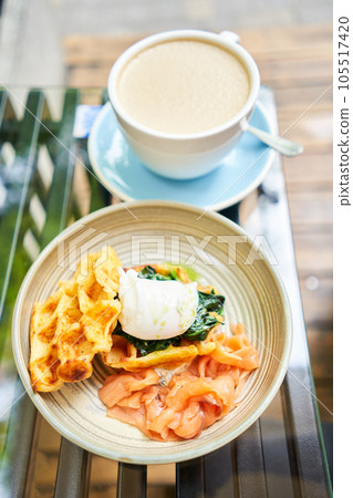 Potato waffles, Poached egg, avocado cream with salmon and egg . Healthy breakfast, protein. Restaurant dish.  105517420