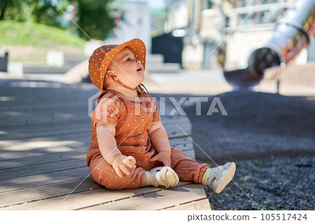Cute child in panama. Portraits of a cute 10 months old baby girl. Walking on the playground, on a sunny summer day. 105517424