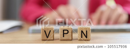 Letters VPN on wooden cubes - Virtual Private Network and Internet user works on computer in background. Letters VPN on wooden cubes - Virtual Private Network and Internet user works on computer in background. 105517936