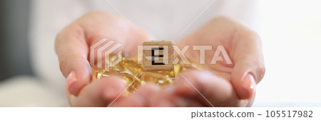 Nutritionist shows capsules of vitamin E or omega-3. 105517982