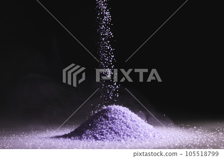 Close up of purple sand thrown in the air and copy space on black background 105518799