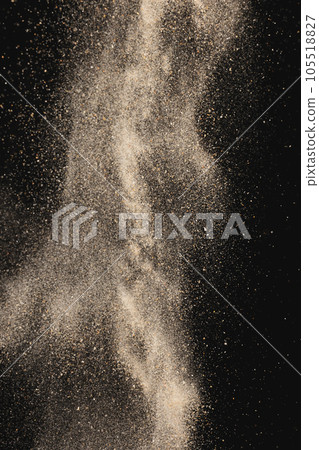 Close up of sand thrown in the air and copy space on black background Close up of sand thrown in the air and copy space on black background 105518827