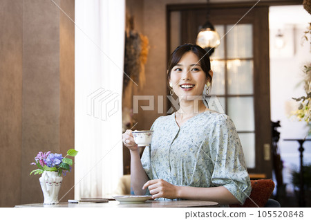 A young woman drinking coffee at a cafe 105520848
