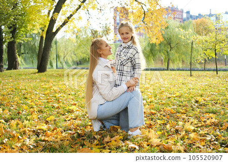 Mother and daughter spend time together in autumn park Mother and daughter spend time together in autumn park 105520907
