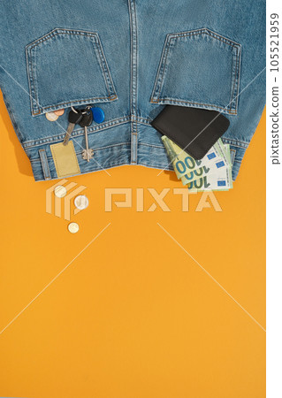 Wallet, bills, coins and keys fly from the back pockets of blue jeans. Wallet, bills, coins and keys fly from the back pockets of blue jeans. 105521959