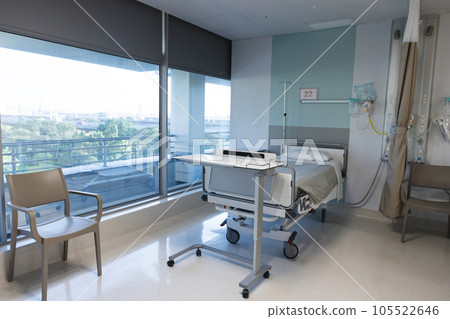 General view of patient room with bed, medical equipment and windows at hospital 105522646