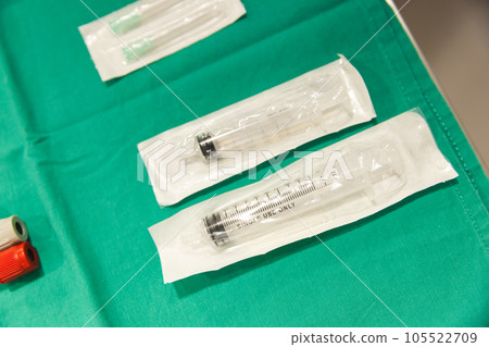 Close up of test tubes and syringes on green material at hospital 105522709
