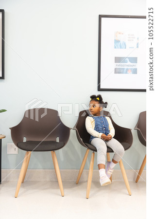 African american girl patient sitting in waiting room at hospital, copy space African american girl patient sitting in waiting room at hospital, copy space 105522715