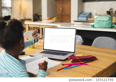 African american girl sitting at table using laptop with copy space for online lesson African american girl sitting at table using laptop with copy space for online lesson 105522749