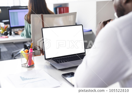 Busy african american casual businessman using laptop with copy space in office Busy african american casual businessman using laptop with copy space in office 105522810