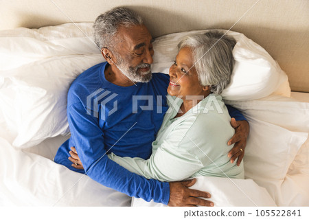 Happy senior biracial couple lying in bed and embracing at home Happy senior biracial couple lying in bed and embracing at home 105522841