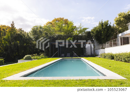 General view of big pool in home garden of modern house on sunny day General view of big pool in home garden of modern house on sunny day 105523067