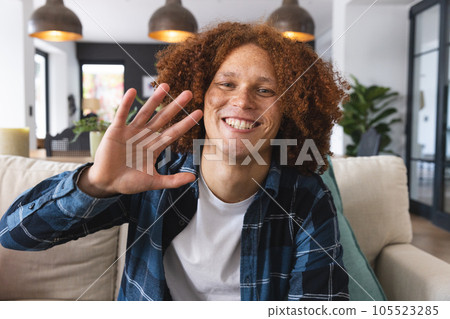 Happy biracial man having video call sitting on couch, waving and smiling in living room, at home 105523285