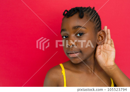 Portrait of happy african american schoolgirl listening at elementary school, copy space 105523794
