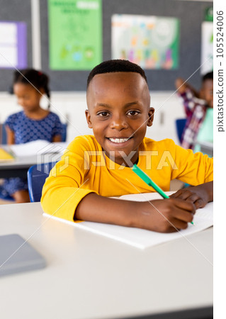 Portrait of happy african american elementary schoolboy sitting at desk in class Portrait of happy african american elementary schoolboy sitting at desk in class 105524006