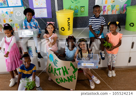 Portrait of happy diverse children with ecology items and plants in class at elementary school 105524214