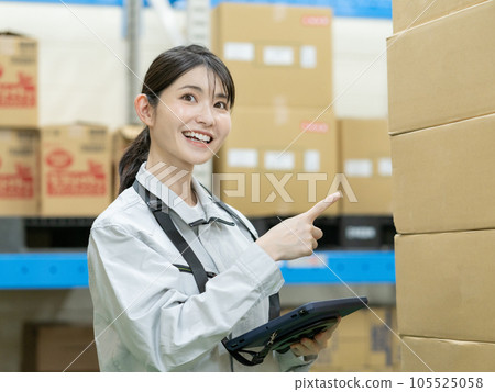 Young female staff managing inventory in a distribution center warehouse 105525058