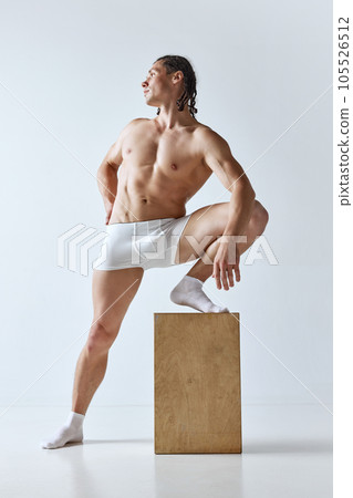 Athletic, handsome man with braids hairstyle posing in underwear against grey studio background. Muscular, fit, strong body shape Athletic, handsome man with braids hairstyle posing in underwear against grey studio background. Muscular, fit, strong body shape 105526512