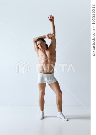 Full-length portrait of handsome mature man with a,muscular body posing in underwear against grey studio background Full-length portrait of handsome mature man with a,muscular body posing in underwear against grey studio background 105526518