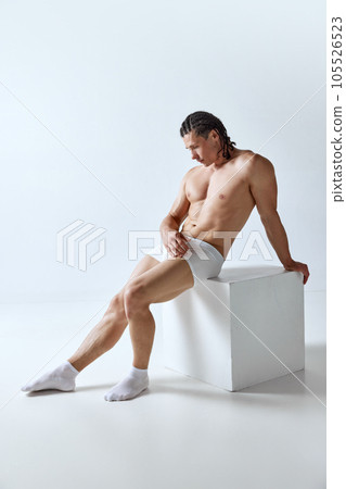 Full-length portrait of muscular handsome man with perfect, fit body shape posing in underwear against grey studio background Full-length portrait of muscular handsome man with perfect, fit body shape posing in underwear against grey studio background 105526523